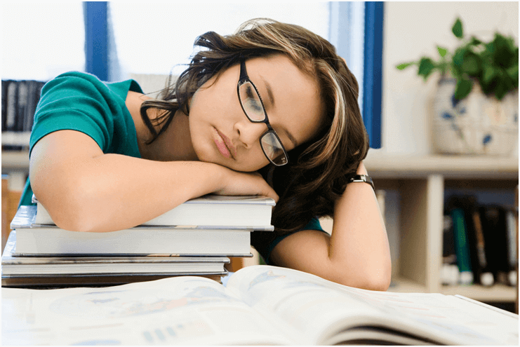 Student sleeping on books