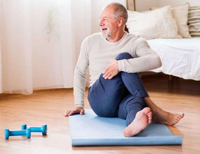 Senior man doing exercise at home