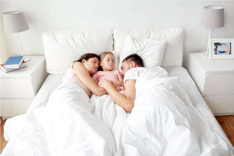 happy-family-sleeping-in-bed-at-home