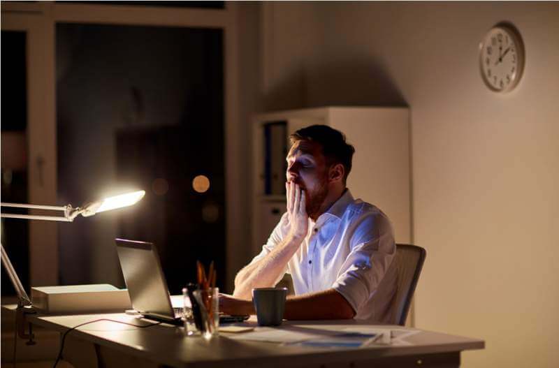man-with-laptop-and-coffee-working-at-night
