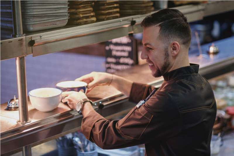 a-young-cook-stands-in-the-kitchen-and-prepares