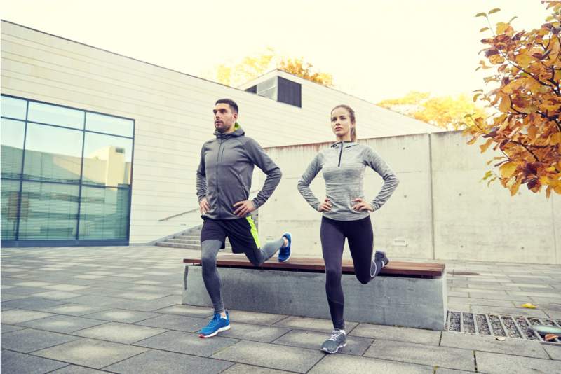 couple-doing-lunge-exercise-on-city-street