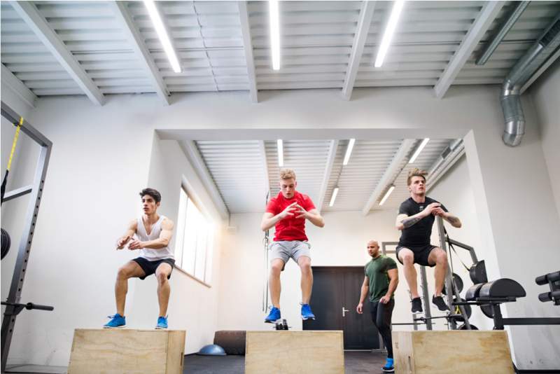men-in-gym-with-trainer-exercising-on-fit-boxes