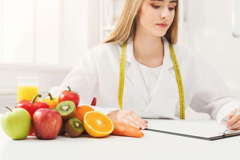 nutritionist-desk-with-fruit-and-measuring-tape