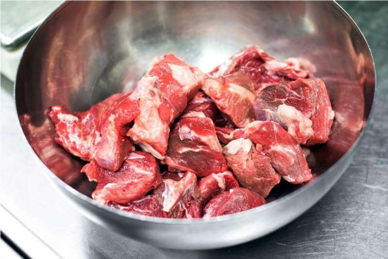 pieces-of-fresh-raw-red-meat-in-a-metal-bowl