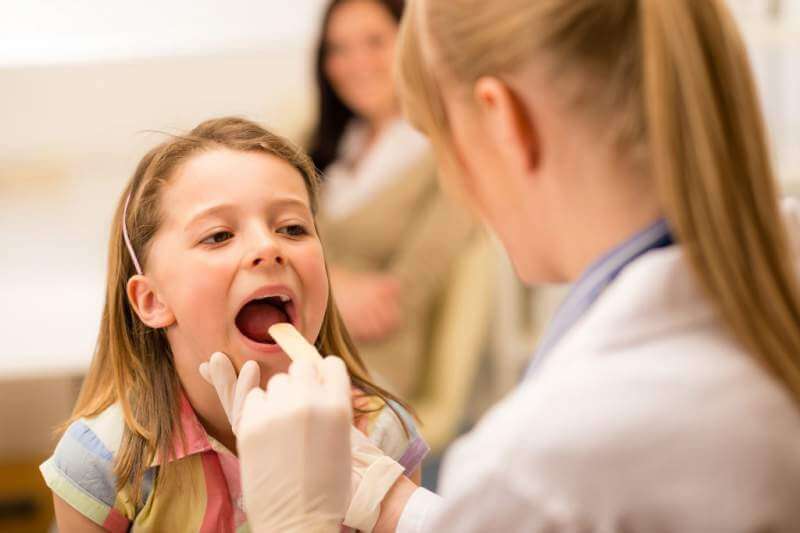 Doctor examing child mouth