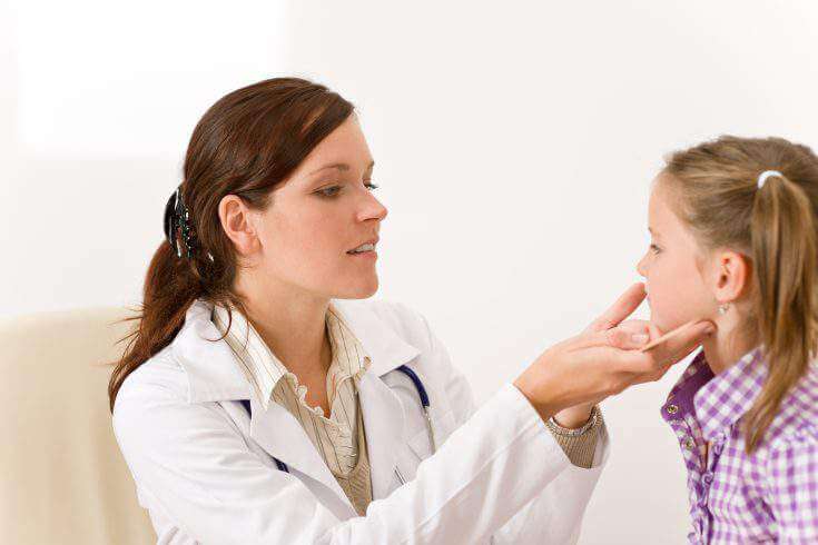 Doctor testing child throat