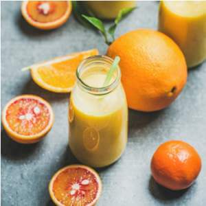 healthy-yellow-smoothie-in-bottle-over-concrete