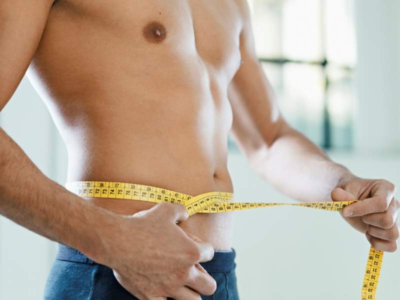 man-measuring-belly-and-waist-with-yellow-tape