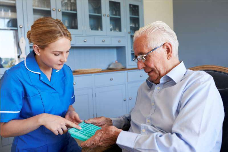nurse-helping-senior-man-to-organize-medication