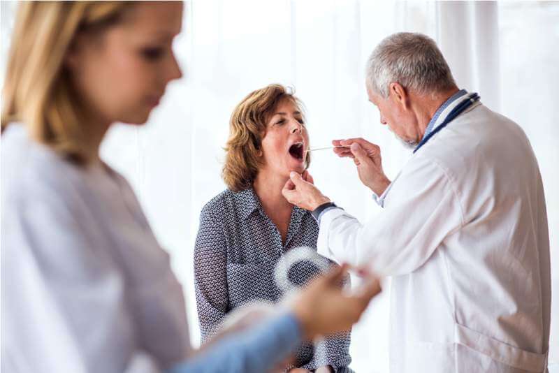 senior-doctor-examining-a-senior-woman-in-office