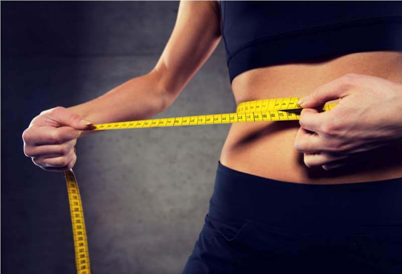 woman-measuring-waist-by-tape-in-gym