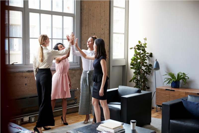 female-colleagues-high-five-at-a-motivational