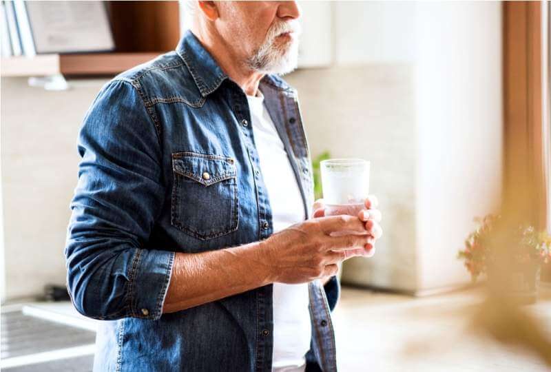 senior-man-holding-a-glass-of-water