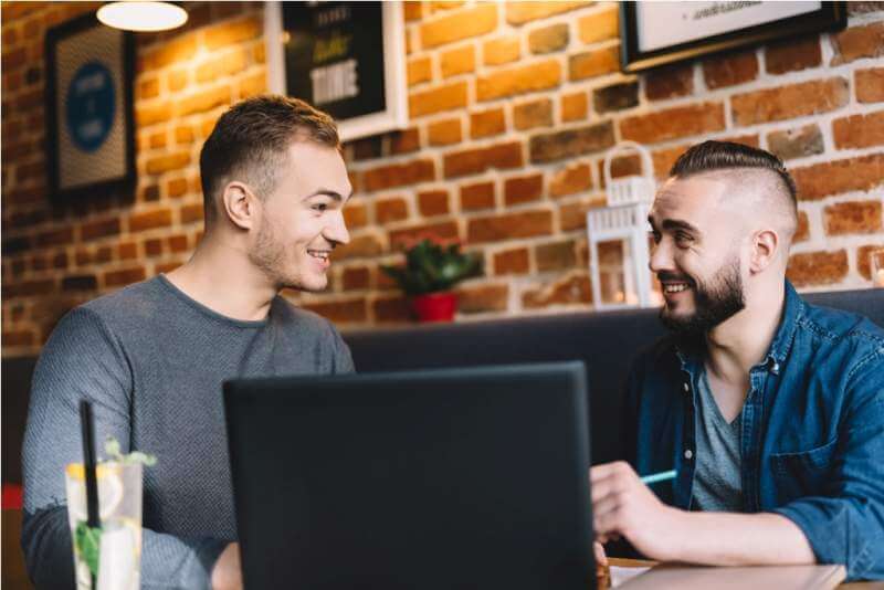 two-men-in-a-good-mood-sitting-by-the-laptop