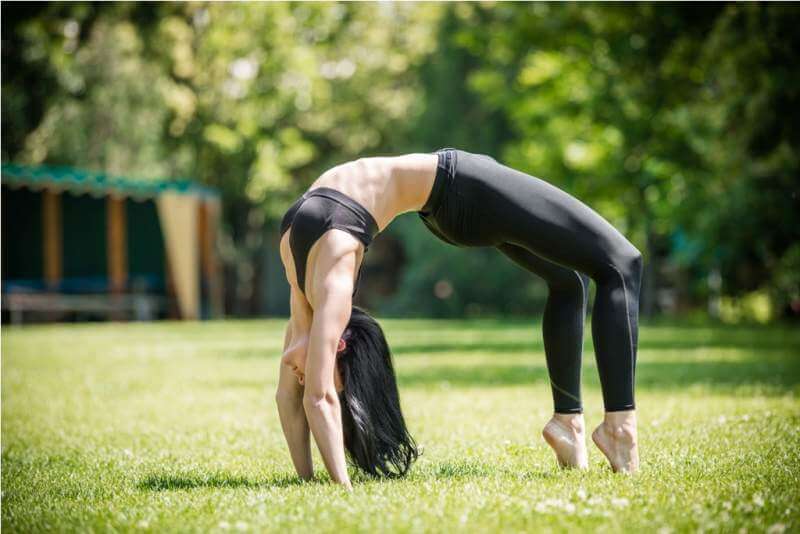 young-woman-performing-bridge-exercise-in-park