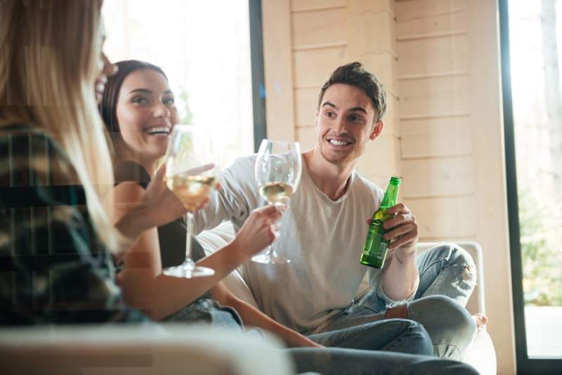 cheerful-young-friends-drinking-wine-and-beer