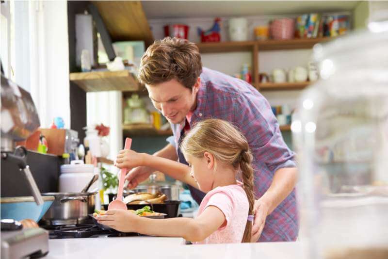 daughter-helping-father-to-cook-meal-in-kitchen