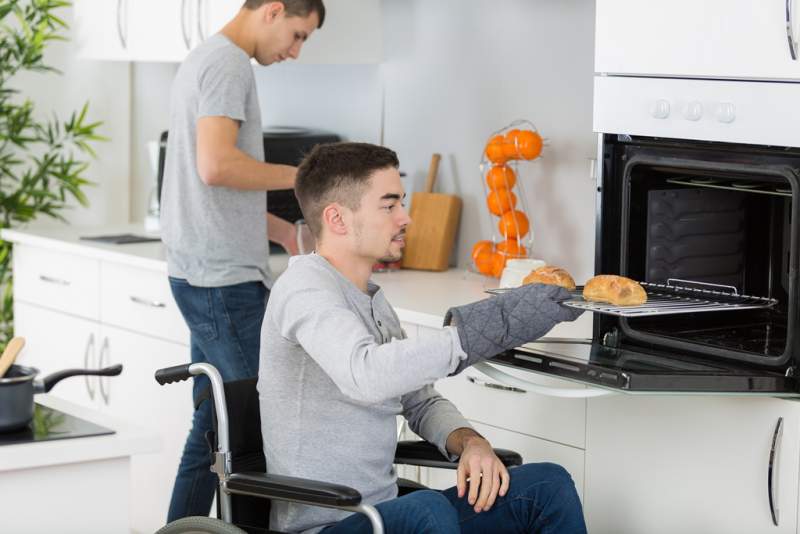 disabled-man-taking-food-from-oven