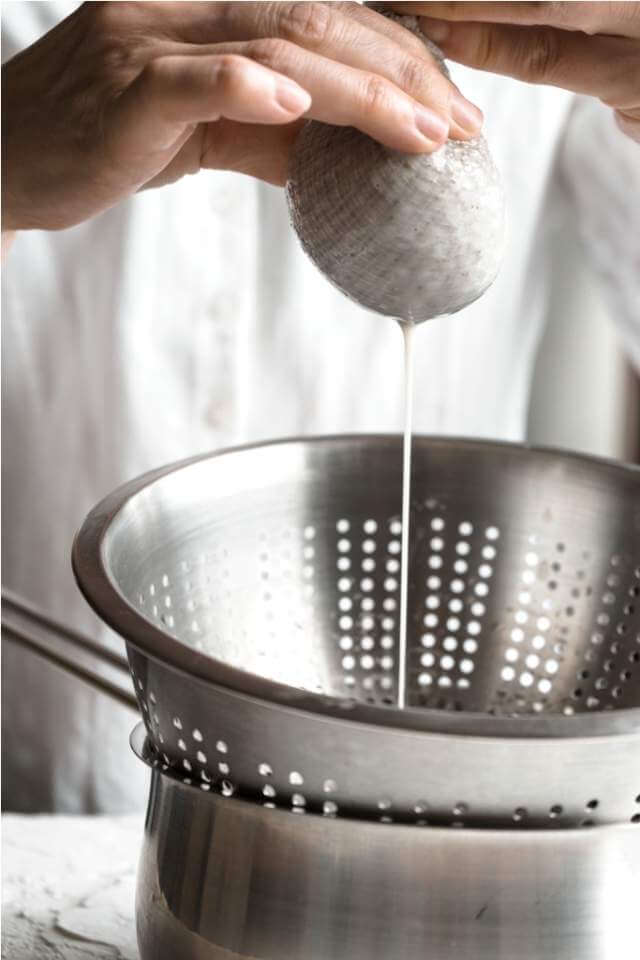 woman-squeezes-the-cannabis-cake-into-a-sieve
