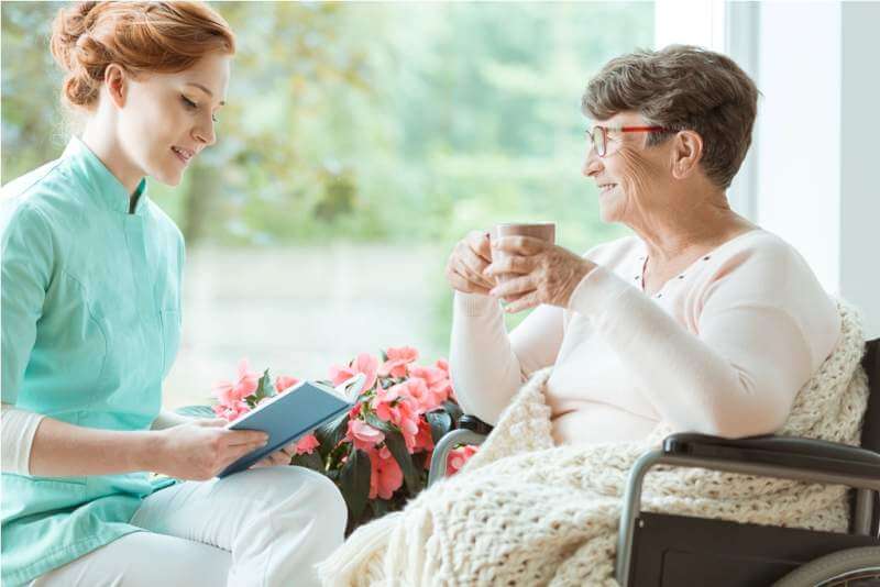 assistant-reading-book-to-elder