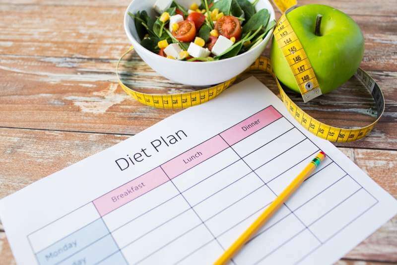 close-up-of-diet-plan-and-food-on-table