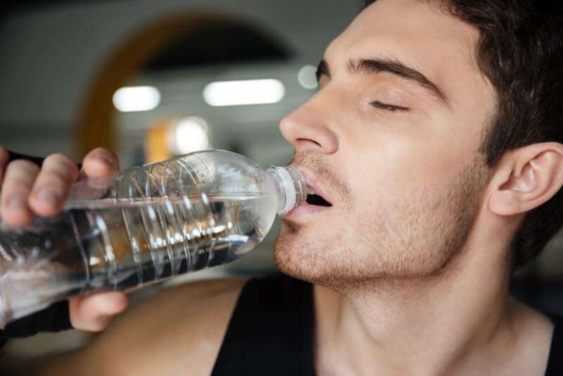 man-sportsman-drinking-water-after-training