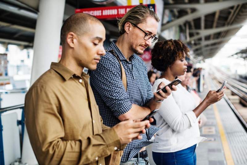 people using mobile phone railway station