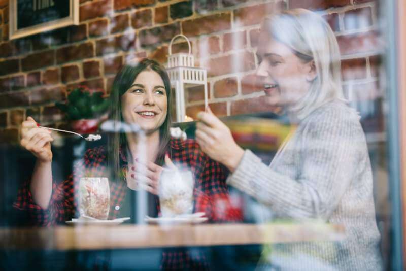 two-women-eating-and-talking-in-a-restaurant