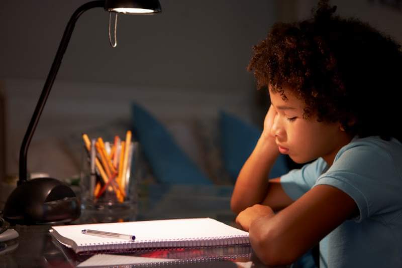 unhappy-young-boy-studying-at-desk-in-bedroom