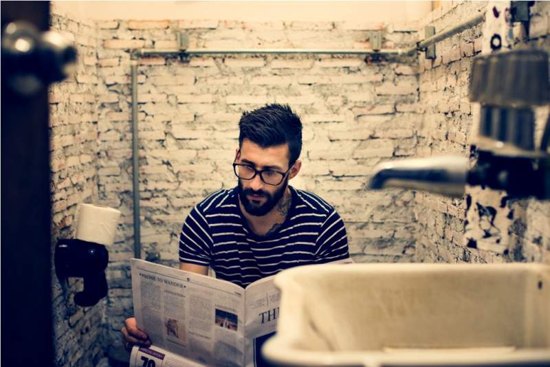 man-in-a-restroom-reading-newspaper