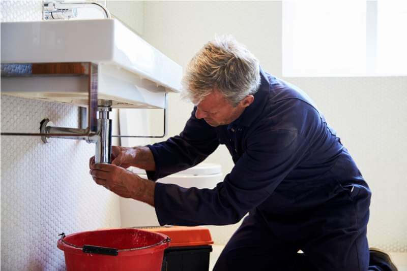 plumber-working-on-sink-in-bathroom