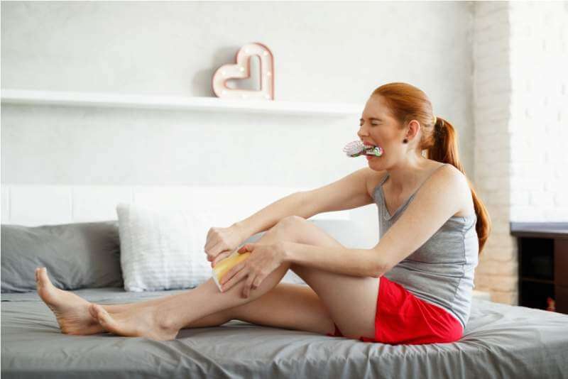 redhead-woman-feeling-pain-waxing-her-legs