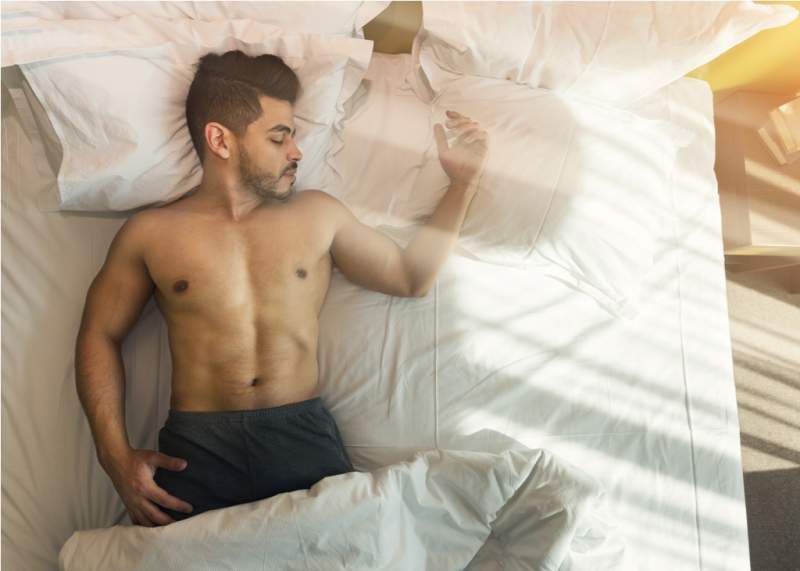 top-view-of-shirtless-young-man-sleeping-in-bed