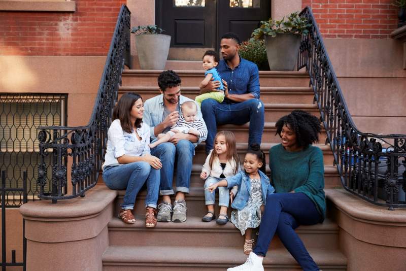 two-families-with-kids-sitting-on-front-stoops