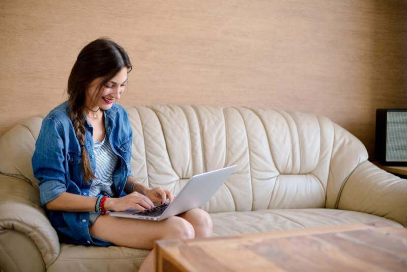 attractive-lady-usig-laptop-on-leather-sofa