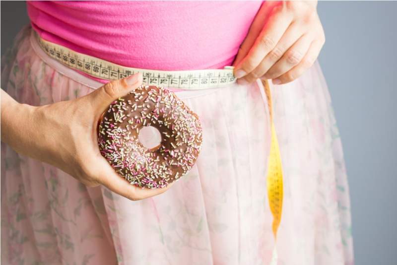 woman-holding-donut-in-hand-and-check-out