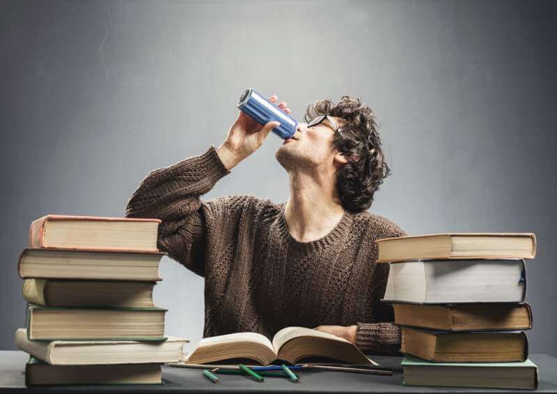 young-man-studying-and-drinking-energy-drink