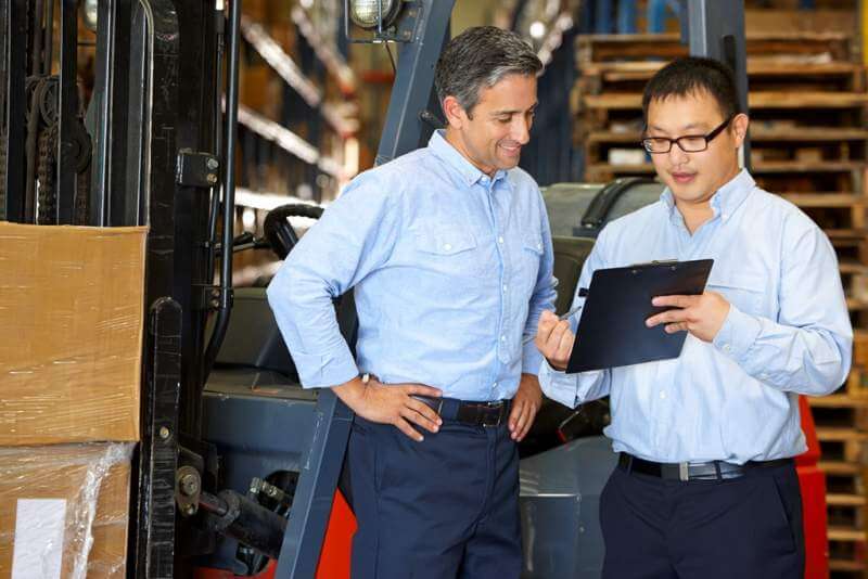 businessmen-meeting-by-fork-lift-truck-in