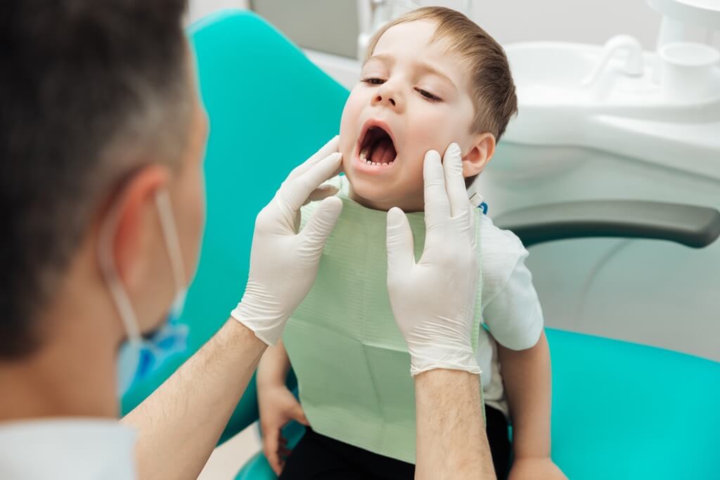 dentist-examining-teeth-of-little-boy-witting