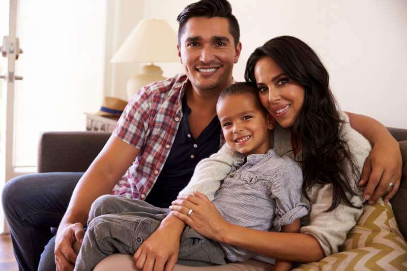 portrait-of-happy-family-sitting-on-sofa