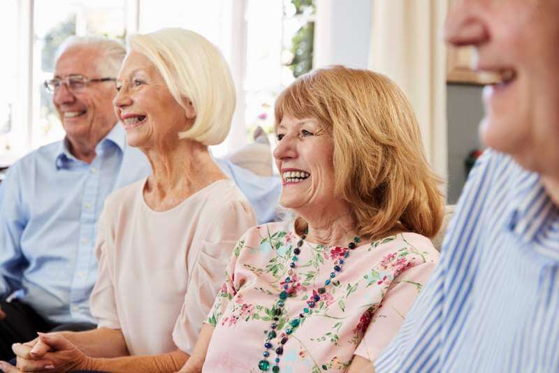 group-of-senior-friends-relaxing-on-sofa-at-home