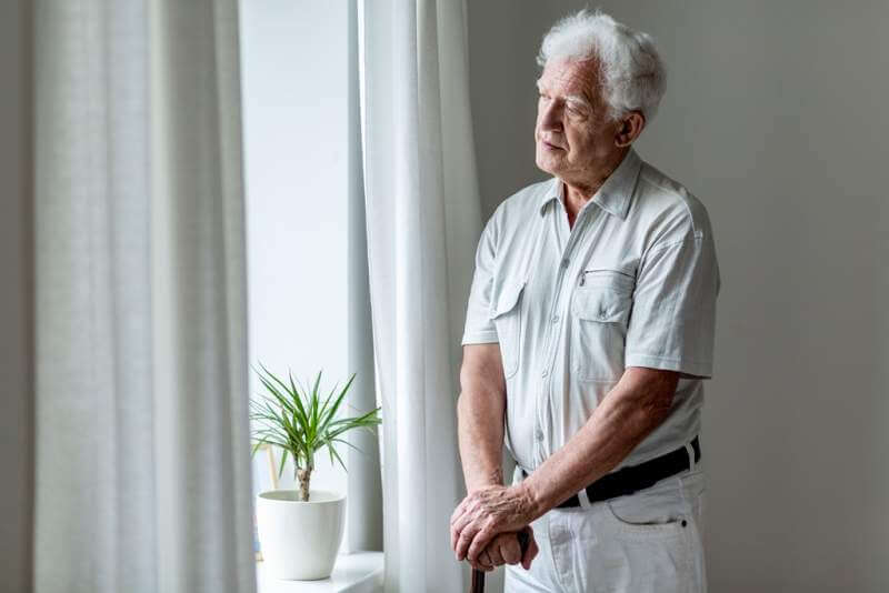 lonely-elderly-man-with-walking-stick-standing