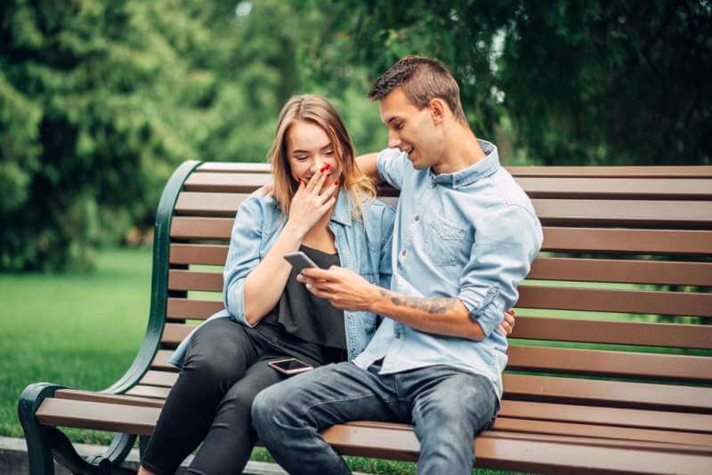 phone-addiction-couple-using-gadget-in-park