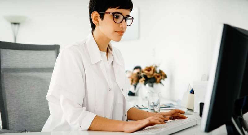 beautiful-female-doctor-typing-receipt