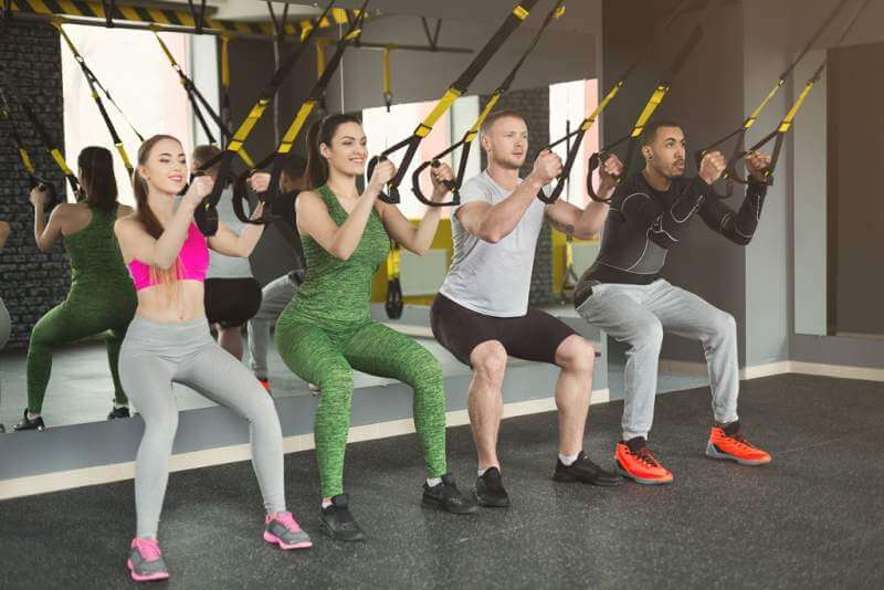 group-performing-trx-suspension-training-in-gym