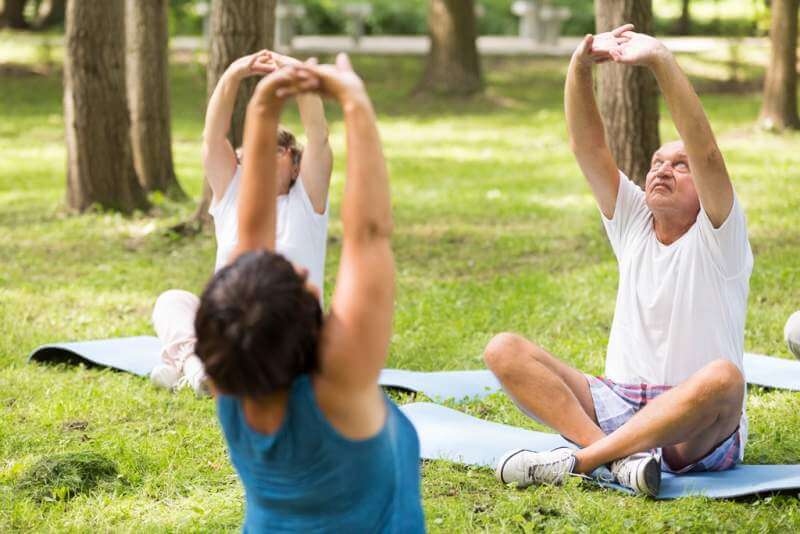 seniors-doing-yoga-in-a-forest