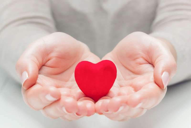 small-red-heart-in-womans-hands-in-a-gesture