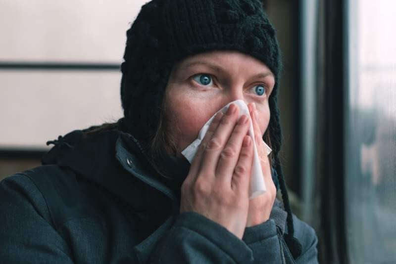 woman-blowing-her-nose-into-paper-handkerchief