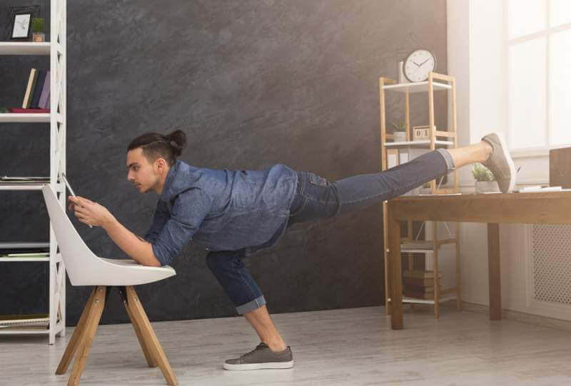 flexible-man-practicing-yoga-at-workplace